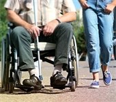 woman walking next to man in wheelchair