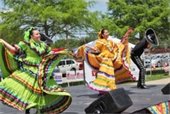 Women dancing in colorful dresses during previous Cinco de Mayo Celebration