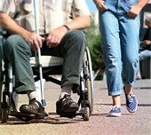 girl walking next to man in wheelchair