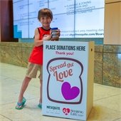 smiling child holding jar of peanut butter 
