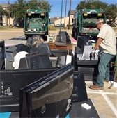 man picks up a bunch of old tvs