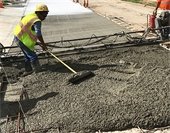 Employees pouring concrete during road repair