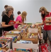 women look through books at book sale