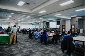 Large room of people sitting at tables for meeting