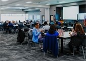 Large room of people sitting at tables for meeting