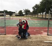 Fifth grader, Jamonta, pictured with his teacher Fredina Guevara posing at tennis court gate entry
