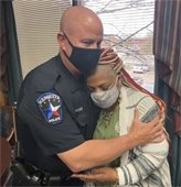 Officer Gafford and resident hug after she gives him citizen commendation