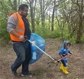 dad and son pick up trash during trash bash