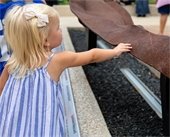 Blonde girl touching beam pulled from former World Trade towers