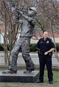 Police Lieutenant George Hensley pictured standing next to his handmade statue, "Amos" 