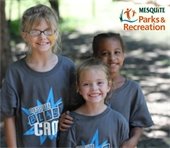 Three young kids wearing "Mesquite Blast Camp" shirts smiling at the camera.