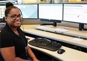 Female dispatcher sitting at her station smiling at the camera