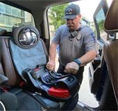 officer installs child safety car seat