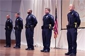 Five new Mesquite Police recruits standing side by side during their academy graduation
