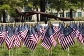 American flags with twisted piece of Twin Towers steel in background