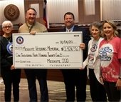 MISD superintendent holding donation check pictured with Mayor Archer and veterans memorial volunteers