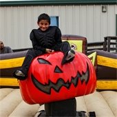 kid riding a pumpkin in batman costume