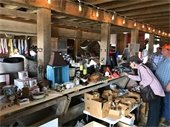 Woman browsing items at previous barn sale 