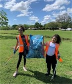two teen girls picking up litter
