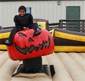 Boy riding pumpkin at pumpkinfest event