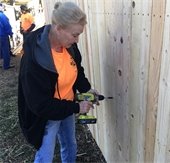 volunteer works on new fence during addressing mesquite day