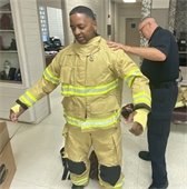 firefighter getting dressed in bunker gear