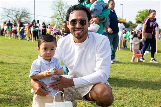 Father and infant child posing for photo at event