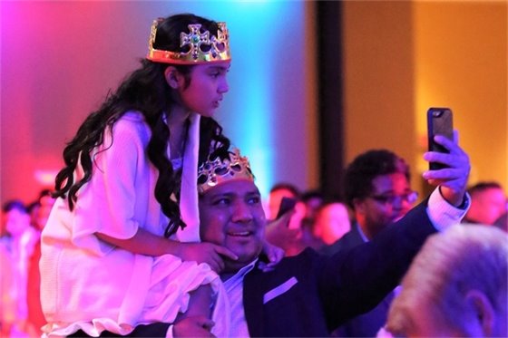 father carrying daughter on his shoulders