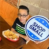 little boy holding shop small sign