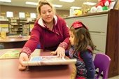 Woman and young daughter reading a book