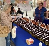 woman  talks to farmers market vendor